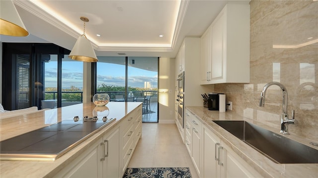 kitchen featuring white cabinetry, sink, and pendant lighting