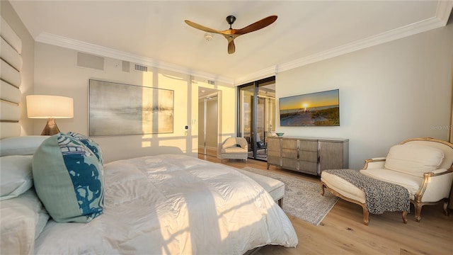 bedroom featuring ceiling fan, light hardwood / wood-style floors, ornamental molding, and a closet