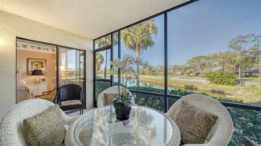 sunroom featuring a water view