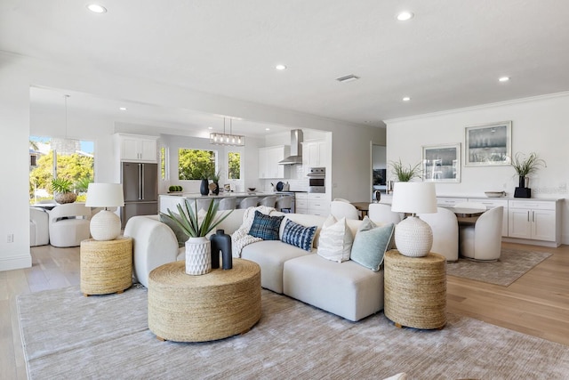 living room featuring light hardwood / wood-style flooring and crown molding