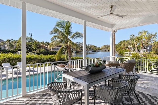 view of patio with ceiling fan, a water view, and a balcony