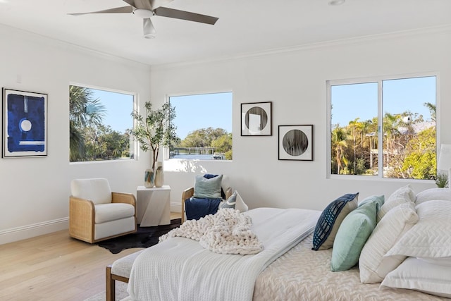 bedroom with ceiling fan, crown molding, and light wood-type flooring