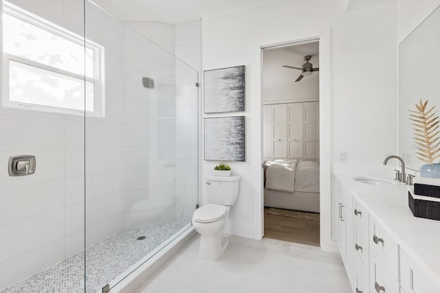 bathroom with a tile shower, ceiling fan, toilet, vanity, and ornamental molding