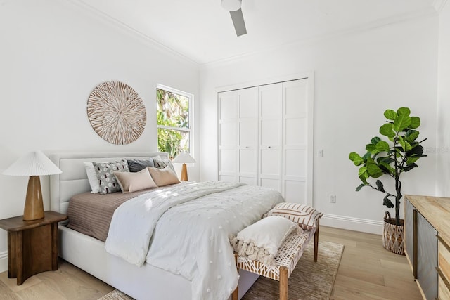 bedroom with ceiling fan, light hardwood / wood-style floors, crown molding, and a closet