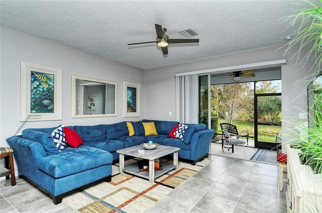 living room featuring ceiling fan and a textured ceiling