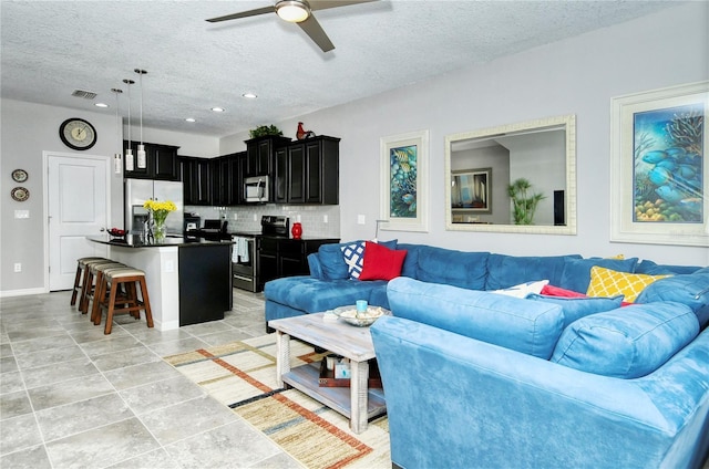 tiled living room featuring ceiling fan and a textured ceiling