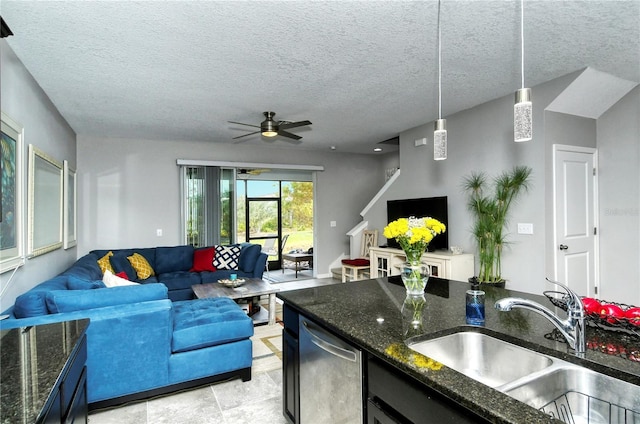 living room with ceiling fan, sink, and a textured ceiling