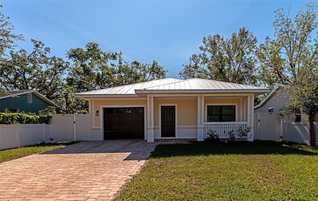 view of front of house featuring a garage, covered porch, and a front lawn