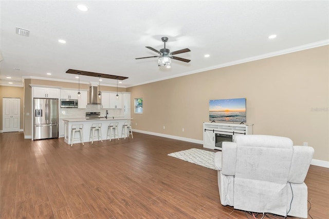 living room with dark hardwood / wood-style floors, ceiling fan, ornamental molding, and sink