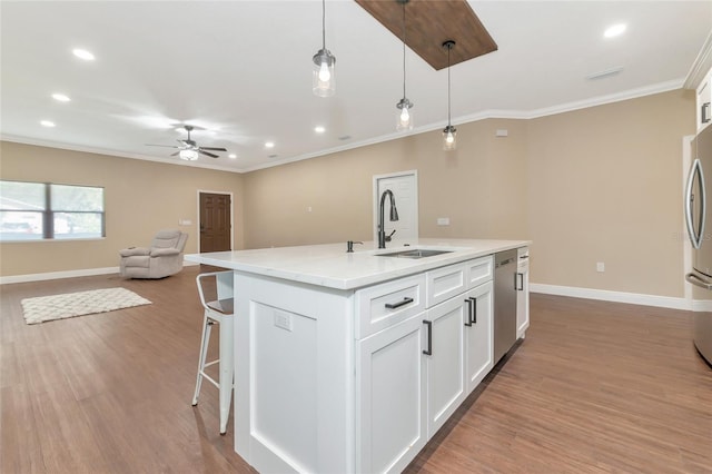 kitchen featuring pendant lighting, a kitchen island with sink, light hardwood / wood-style flooring, ceiling fan, and white cabinetry