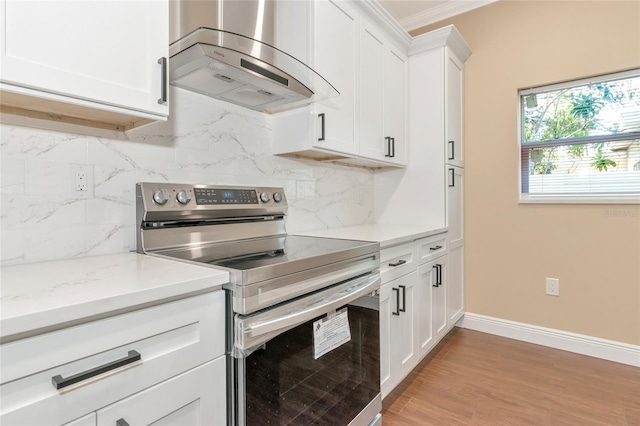 kitchen featuring white cabinetry, stainless steel electric range oven, range hood, and light wood-type flooring