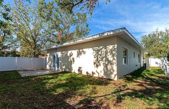 view of home's exterior with a patio area, a yard, and cooling unit