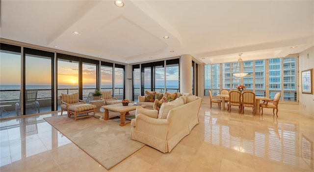 living room featuring floor to ceiling windows, a water view, and light tile patterned floors