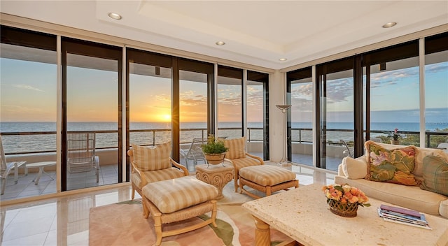 sunroom / solarium with a view of the beach and a water view