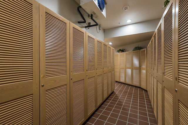 hall featuring dark tile patterned flooring