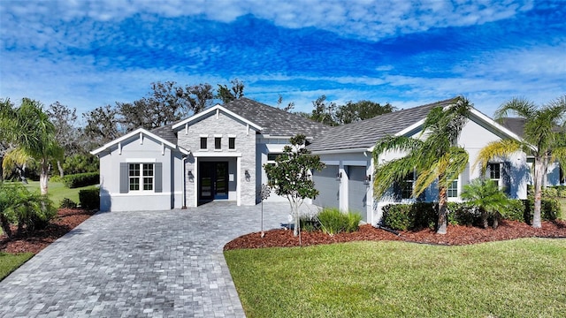 view of front of property featuring a garage, french doors, and a front lawn