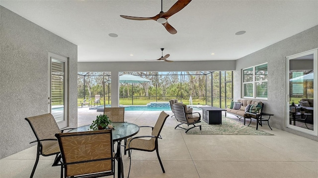 sunroom / solarium with ceiling fan and a pool