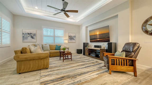 living room featuring a tray ceiling, ceiling fan, and wood ceiling