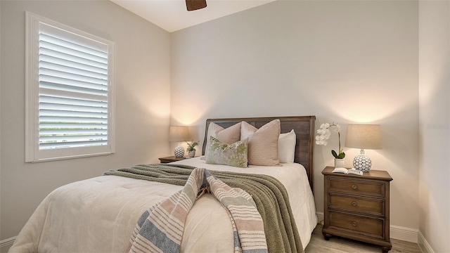 bedroom with multiple windows, light hardwood / wood-style floors, and ceiling fan