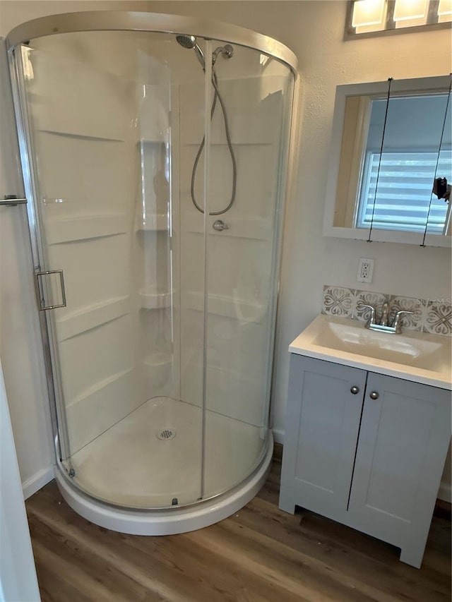 bathroom featuring vanity, wood-type flooring, and walk in shower