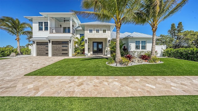 view of front of home featuring ceiling fan, a balcony, french doors, and a front yard