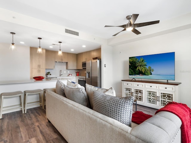 living room featuring ceiling fan, sink, and dark wood-type flooring