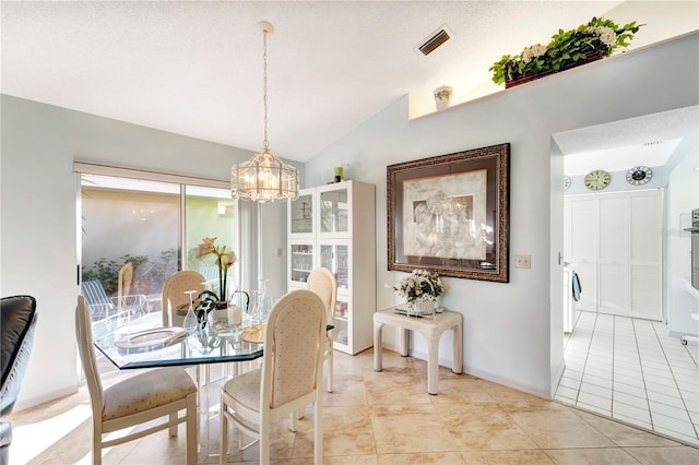 tiled dining area with lofted ceiling, a textured ceiling, and an inviting chandelier