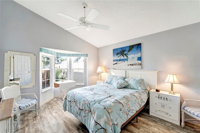 bedroom with hardwood / wood-style flooring, vaulted ceiling, a textured ceiling, and ceiling fan