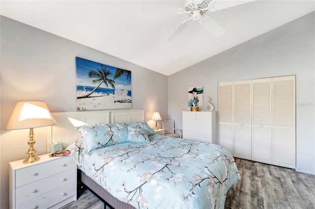 bedroom with ceiling fan, vaulted ceiling, a closet, and light hardwood / wood-style flooring