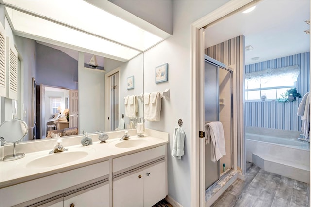 bathroom featuring hardwood / wood-style flooring, vanity, and shower with separate bathtub