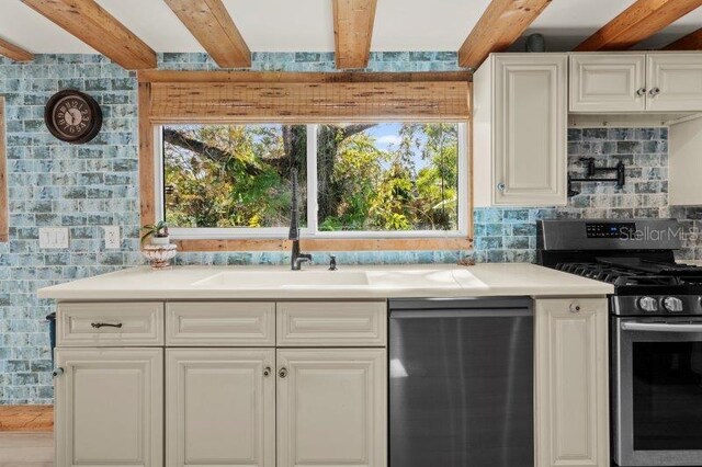 kitchen with white cabinets, decorative backsplash, beam ceiling, and appliances with stainless steel finishes