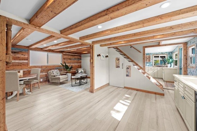 interior space with beamed ceiling, light hardwood / wood-style floors, and wood walls