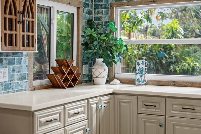 interior space with tasteful backsplash and white cabinetry