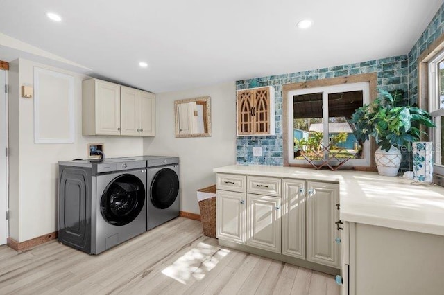 laundry room with cabinets, independent washer and dryer, and light hardwood / wood-style flooring