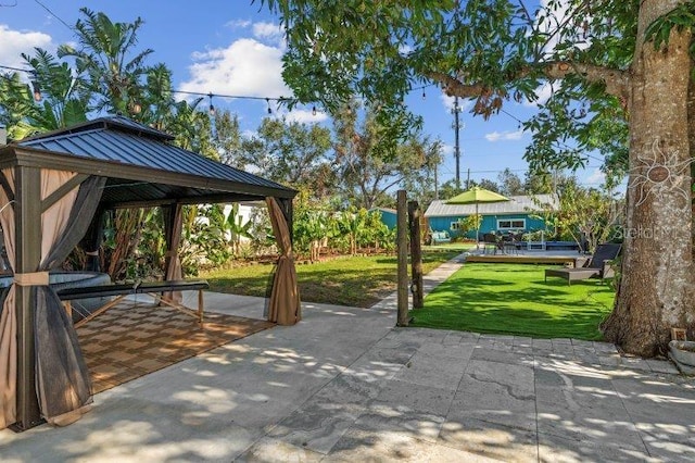 view of community featuring a gazebo, a yard, and a patio area