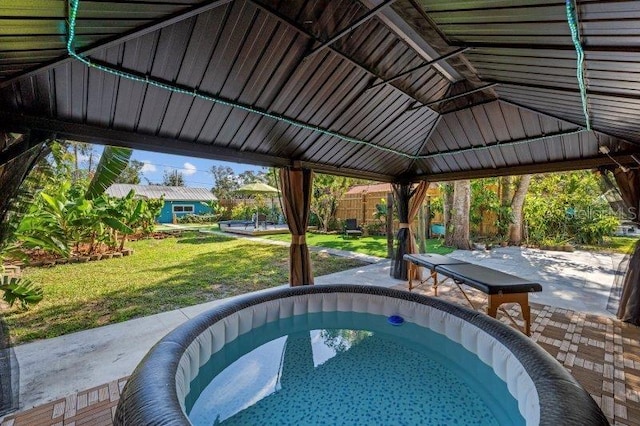 view of swimming pool featuring a lawn, a patio area, a gazebo, and a hot tub