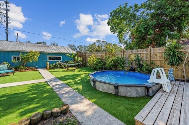 view of swimming pool with a yard and a wooden deck