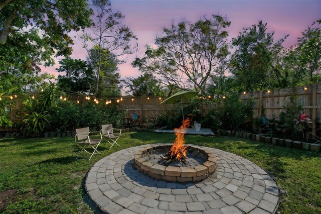 yard at dusk featuring an outdoor fire pit