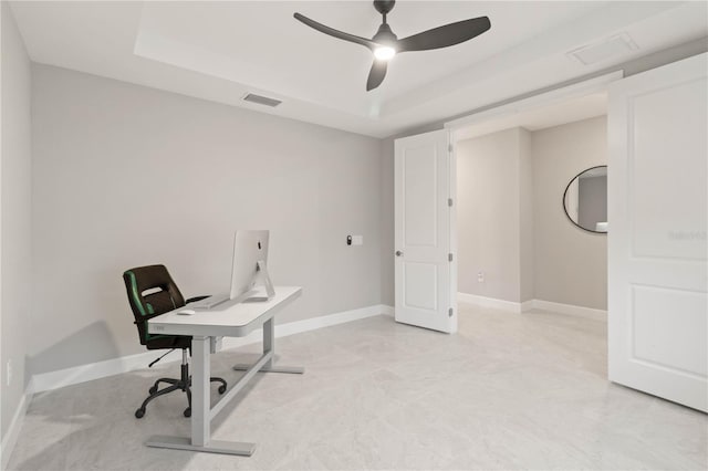 home office featuring ceiling fan and a raised ceiling