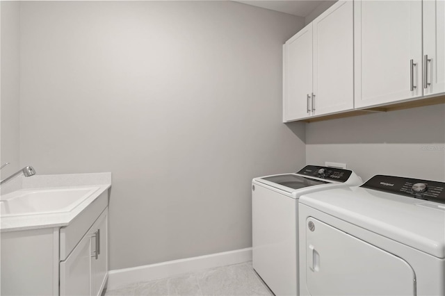 laundry area featuring washing machine and clothes dryer, light tile patterned flooring, cabinets, and sink