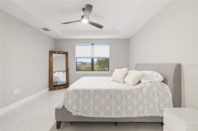 bedroom with a tray ceiling and ceiling fan