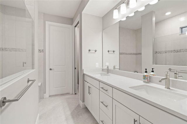 bathroom with vanity and tiled shower