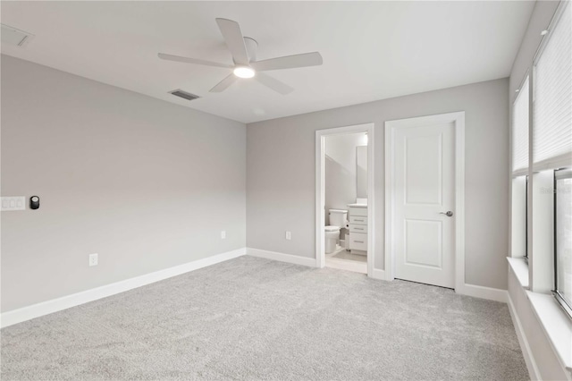 unfurnished bedroom featuring ceiling fan, light colored carpet, and connected bathroom