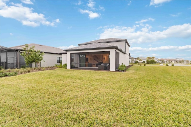 rear view of property with a lawn and a sunroom