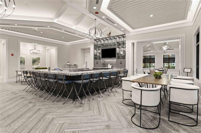 kitchen featuring beamed ceiling, crown molding, and a breakfast bar area