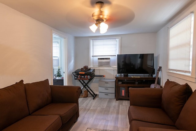 living room with ceiling fan, cooling unit, and light hardwood / wood-style flooring