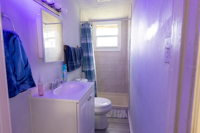 2029 Palm Ter, Sarasota, FL 34231 - full bathroom featuring vanity, a textured ceiling, a stall shower, and wood finished floors