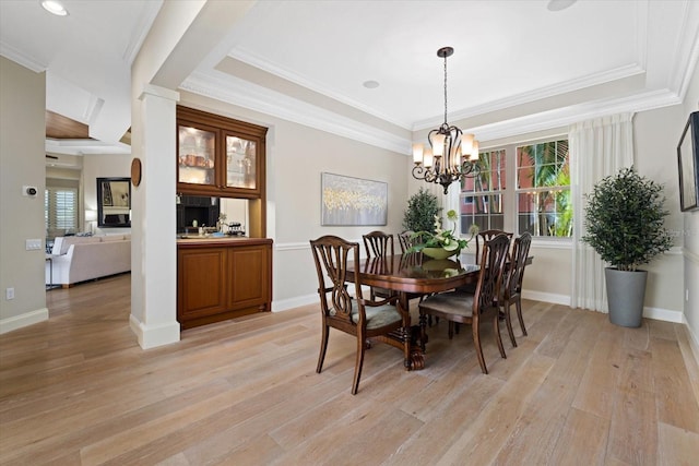 dining area with a healthy amount of sunlight, light wood-type flooring, and ornamental molding