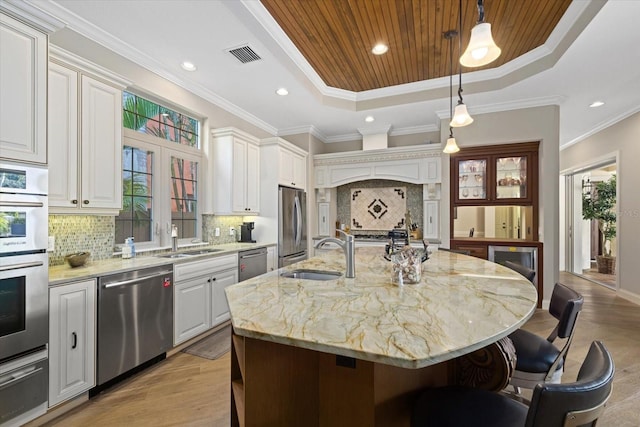 kitchen featuring stainless steel appliances, a kitchen island with sink, light hardwood / wood-style floors, and sink