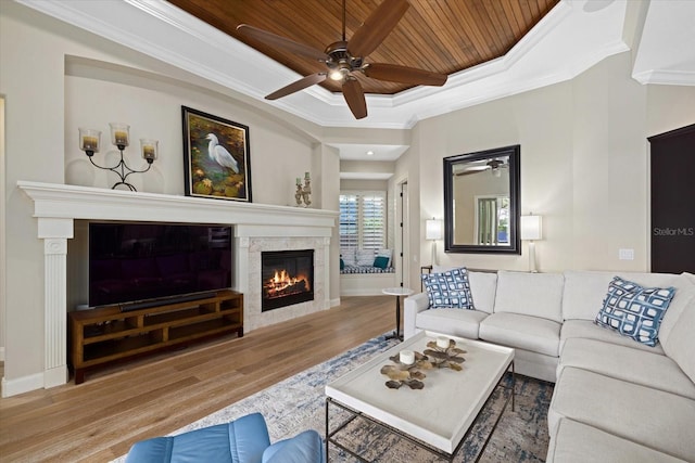 living room with a tray ceiling, crown molding, hardwood / wood-style floors, and wood ceiling